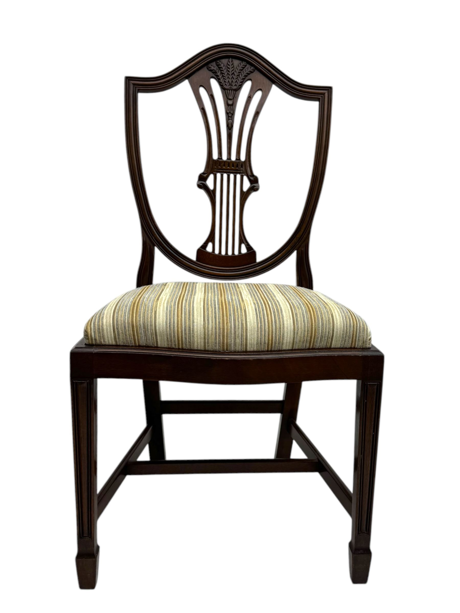 
Late Victorian mahogany extending dining table and four chairs, rectangular top with rounded corners and moulded edge, fitted with two additional leaves, raised on turned and reeded legs with brass castors, with a pair of Victorian mahogany hall chair, with curved top rail and plain splat, padded seat in textured salmon pink fabric, raised on turned and tapering front legs and another pair of early 20th century mahogany dining chair, with shield back and carved pierced splat, serpentine seat rail with striped upholstered cushion, raised on moulded square front legs