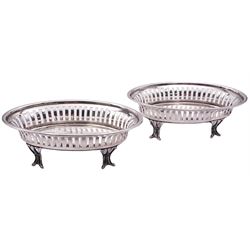 Pair of Edwardian silver bon bon dishes, each of oval form with vertical pierced sides, upon four open stylised scrolling feet, hallmarked Birmingham 1909, makers mark probably T Wooley, H4.5cm L14.5cm, approximate weight 5.63 ozt (175.2 grams)