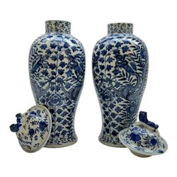 Pair of Chinese vases and covers, of baluster form the blue and white design depicting dragons in foliage, with character marks beneath, H38cm