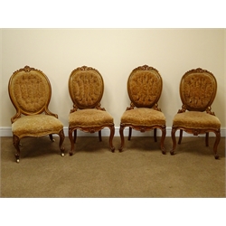 Set of three Victorian walnut and parcel gilt salon chairs, floral carved cresting rail, buttoned back and serpentine seat on acanthus carved cabriole legs, and a matching nursing chair (4)  