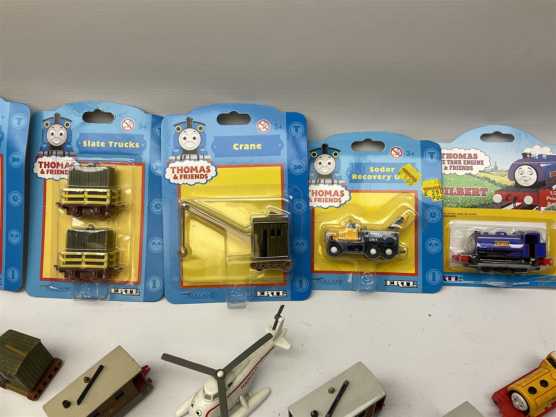 Ertl Thomas the Tank Engine and Friends die-cast models including carded Scrap Trevor, Slate Trucks, Neil, Wilbert, Sodor Taxi, Sodor Recovery Unit, Crane and four key rings; together with various uncarded models including locomotives, coal wagons, steam rollers, boat transporter, recovery units etc (over forty items)