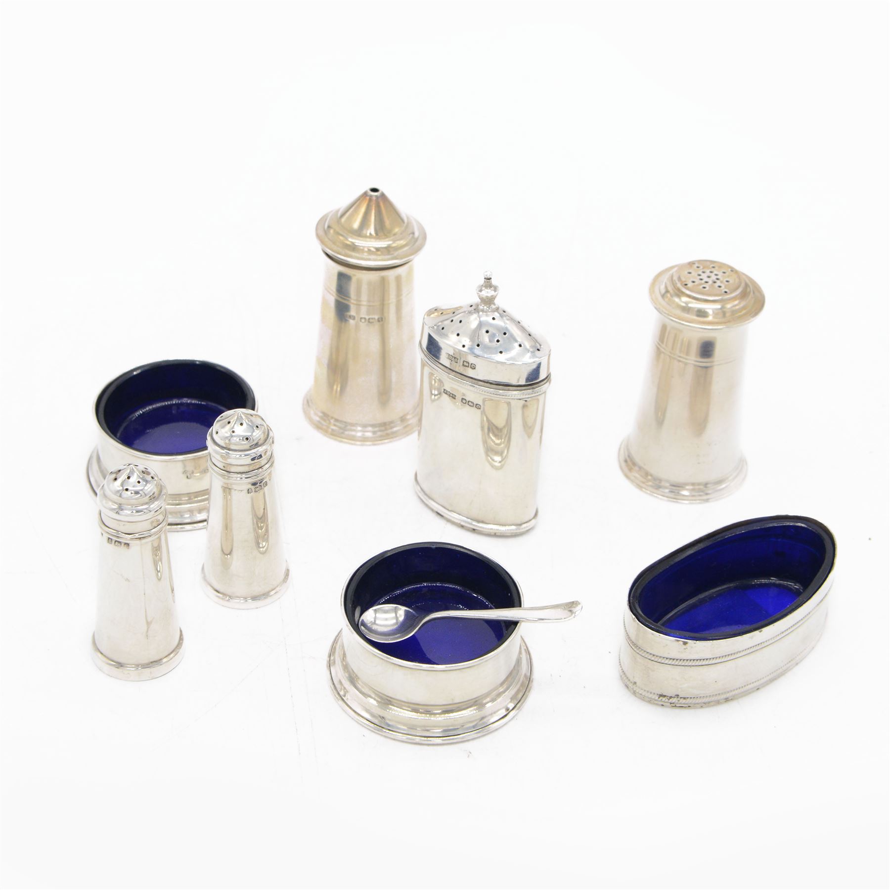 Group of silver cruet items, comprising pair of Art Deco salt and pepper shakers, of tapering cylindrical form, hallmarked Viner's Ltd, Sheffield 1933, pair of silver open salts, pair of salt shaker, and a matching pepper shaker and open salt, all hallmarked