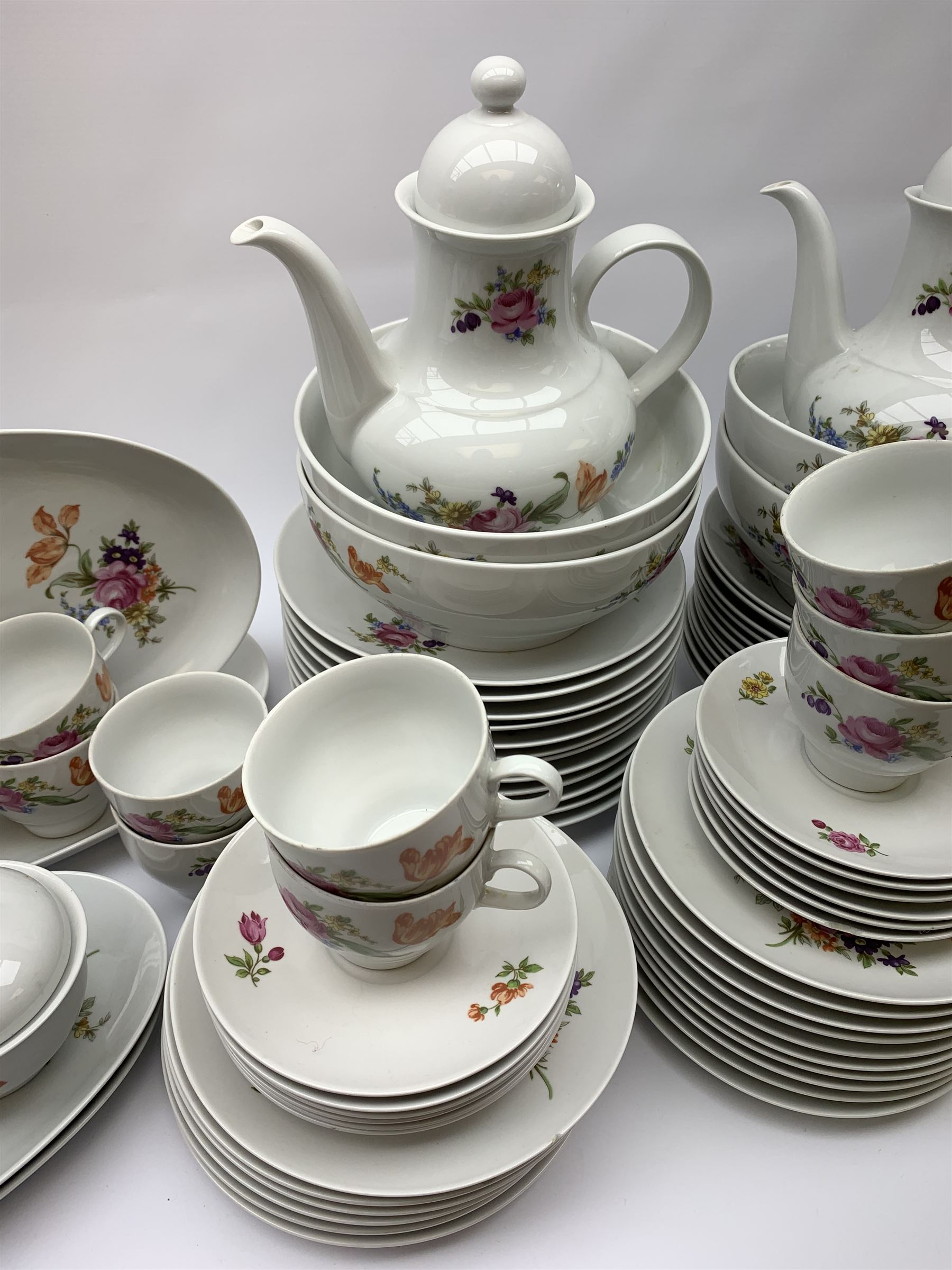 JLmenau German tea and dinner wares, comprising twelve dinner plates, seventeen side plates, twelve bowls, four large serving bowls, pair of oval serving platters, pair of smaller examples, two coffee pots, eleven teacups, twelve saucers, two milk jugs, two larger jugs, and two lidded sucriers. 
