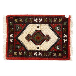 Long flatweave Kilim textile cushion, in crimson and decorated with geometric motifs and cotton fringe ends, 151cm, together with four modern hand-knotted rug mats with geometric designs, the largest 65x43cm, (5)