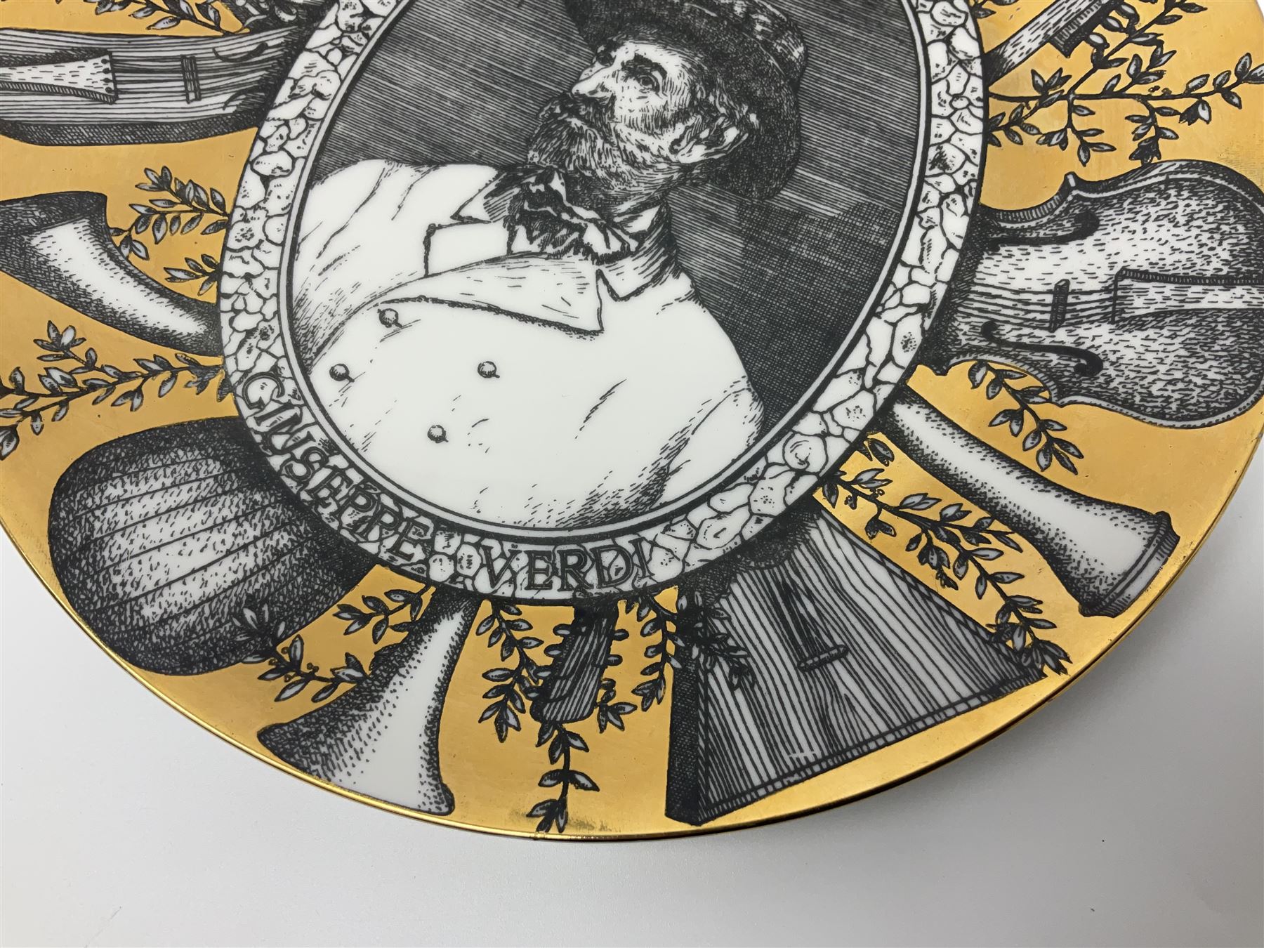 Fornasetti Grandi Maestri plate, depicting Giuseppe Verdi within a border of operatic emblems on gilt ground, with printed mark beneath, D25cm