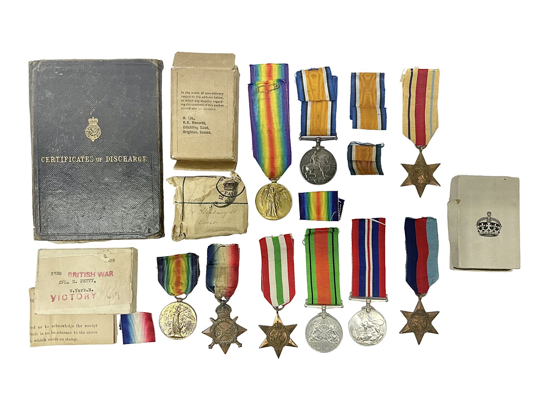 WWI pair of medals comprising British War Medal and Victory Medal awarded to 32682 Pte. W. Meadows W. Rid. R. in issue box; WWI pair of medals comprising 1914-15 Star and Victory Medal awarded to 3720 Pte. (later Cpl.) E. Petty W. York. R. with issue letter from Tank Corps; WWII group of five medals comprising 1939-45 War Medal, Defence Medal and 1939-45, Italy and Africa Stars; all with ribbons; and book of nineteen seaman's Certificates of Discharge to cook Charles Filburn 1893 - 1901 from various British ports