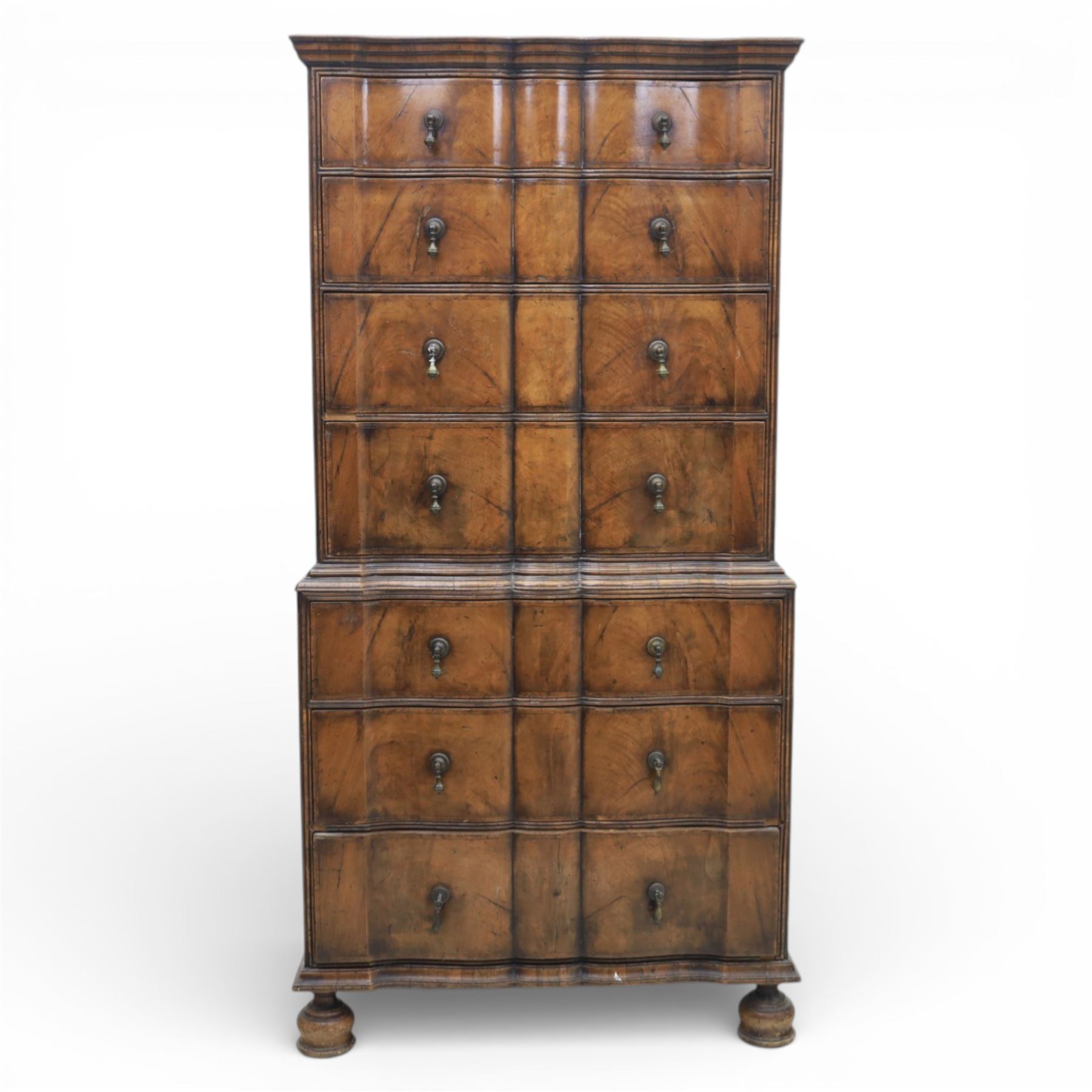 Early 20th century Queen Anne revival walnut chest on chest, the shaped cornice over an arrangement of four long drawers above three further long drawers, figured walnut veneers with feather banding and crossbanding, on turned bun supports