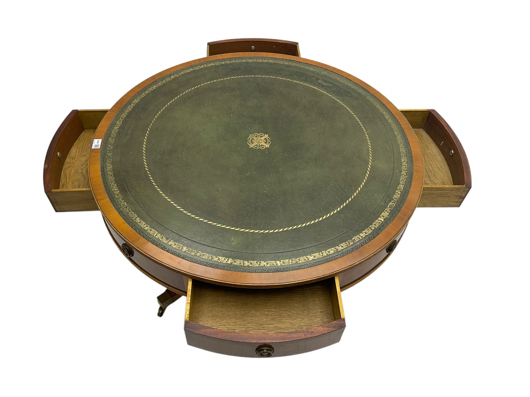 Georgian style yew wood drum table, circular top with green and tooled leather inset, fitted with four drawers, on turned pedestal base with four splayed supports, brass cups and castors