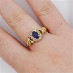 18ct gold sapphire and diamond cluster ring, single oval cut sapphire of approx 0.50 carat, surrounded by fourteen round brilliant cut diamonds, with pierced crossover diamond set shoulders, stamped, total diamond weight approx 0.20 carat