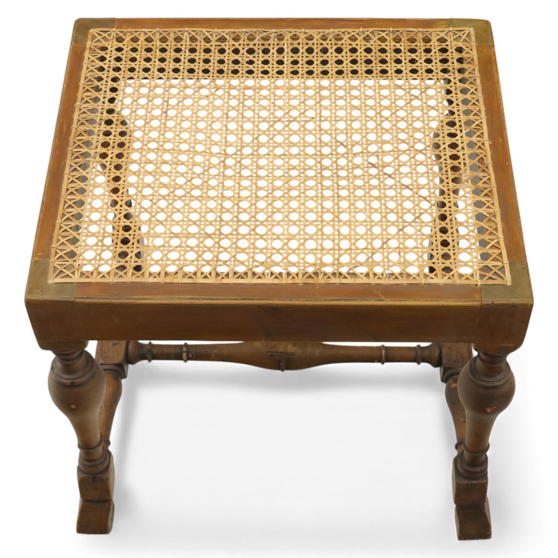 Two upholstered and caned footstools, a late Victorian carved mahogany footstool, oval form upholstered in geometric kilim-style fabric, on cabriole supports (H 27cm, W 56cm, D 47cm), together with a 20th century beech stool, square caned seat on turned supports united by stretchers (H 43cm, W 44cm, D 37cm)