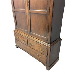 George III oak livery cupboard, projecting moulded cornice over two panelled doors, the upper panels within stepped ogee and arched moulded frame, the interior fitted with a single row of wooden hooks, two short and one long drawers, on bracket and return skirted base 