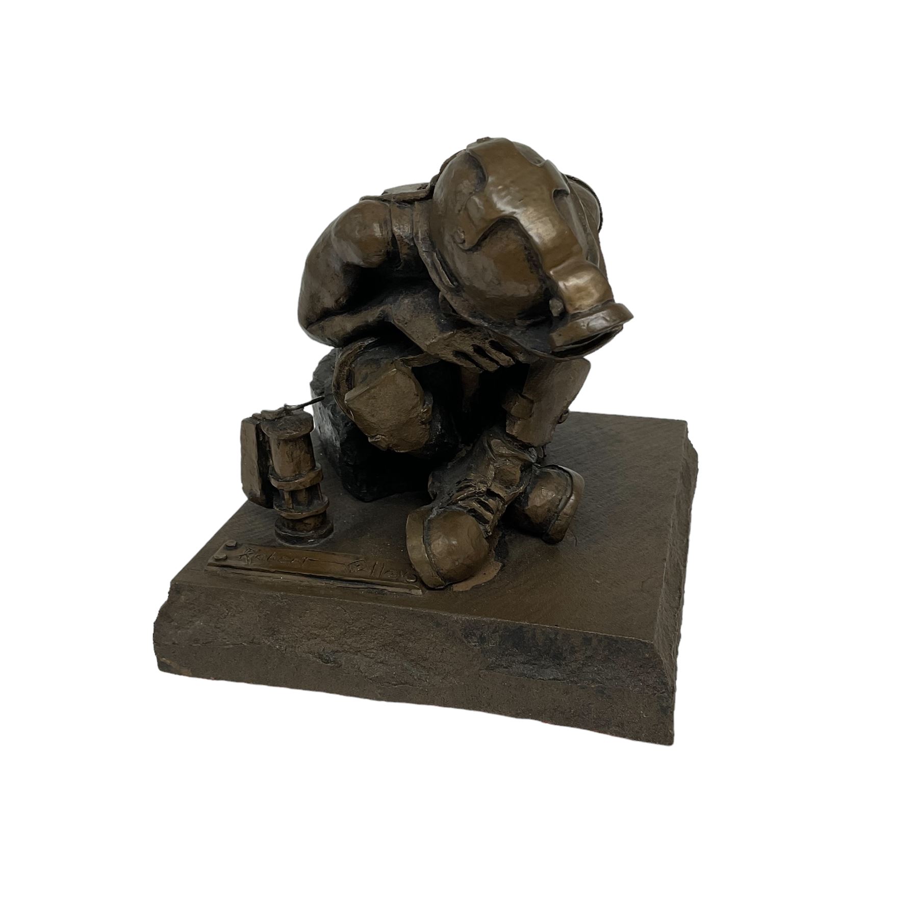 Bronzed cold cast figure of a miner sat beside a lamp by Robert Olley on rocky square plinth base, H17cm