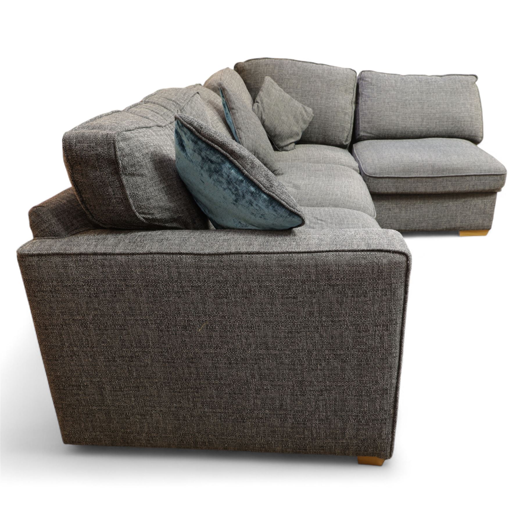 Contemporary grey fabric corner sofa and ottoman, comprising modular sections with removable back and seat cushions, raised on light wood block feet