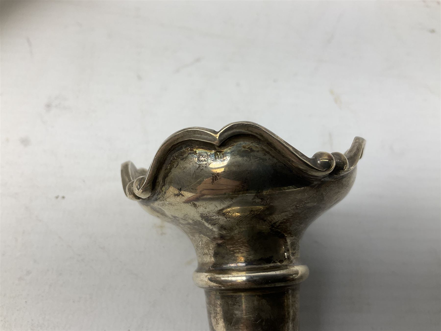 Four hallmarked silver trumpet vases, total weight 108g, upon silver plated stand with foliate decoration and bun feet