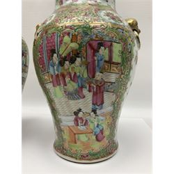 Pair of 19th century Chinese Famille Rose vases and covers, each of baluster form with twin gilt lion mask ring handles to shoulders, the flattened domed covers with gilt temple lion finials, each decorated with alternating reserves of bijin and attendants, and birds and butterflies amongst blossoming peonies, against a gilt ground profusely decorated with stylised scrolls, H32.5cm