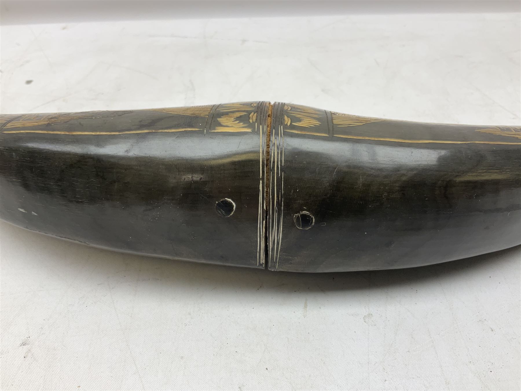 Carved water buffalo horn wall pocket, engraved with landscape scene with patterned borders with pierced foliate panel, together with a pair of horns with similar engraved decoration, L47cm