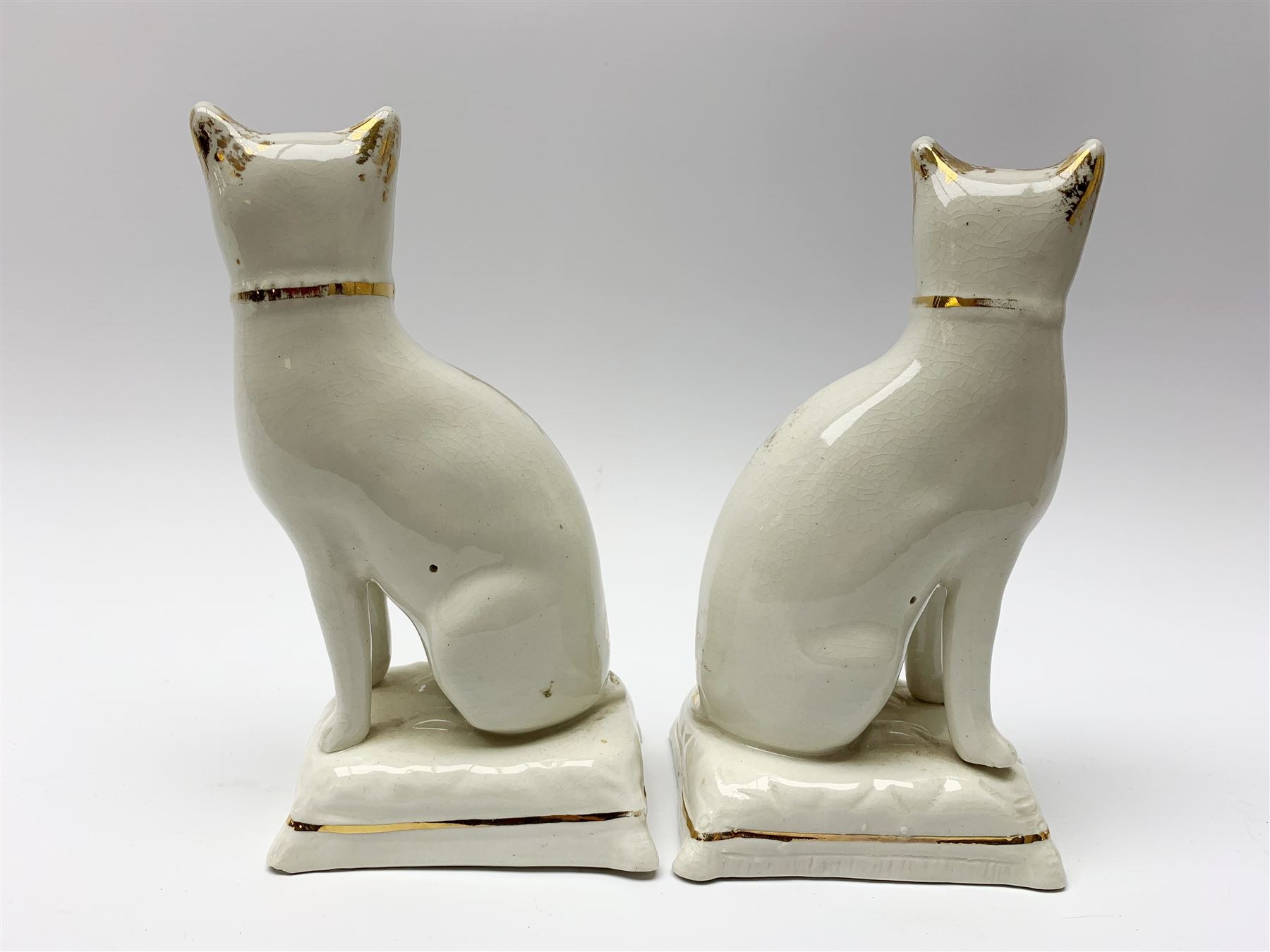 Pair of Victorian Staffordshire cats, modelled seated upon cushions, with gilt detail throughout, H18cm