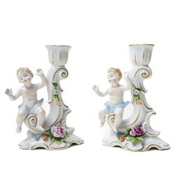 Collection of German and continental porcelain figures, including a figure of Juno with peacock, two figures feeding birds on benches, cherub candlesticks, and others