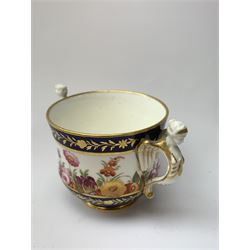 Early 19th century Spode chocolate cup and cover, with twin figural winged handles, decorated with a continuous band of flowers between dark blue gilt detailed borders, H8cm, together with a similarly decorated spill vase, H10.5cm, and a 19th century Ridgway dish, decorated with flowers and moulded cornucopia within a gilt hatched dark blue border, pattern number verso 2/852, D19cm
