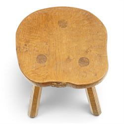 Squirrelman - rustic oak milking stool, adzed shaped top with exposed peg construction, on three tapering supports, with large carved squirrel signature, by Wilf Hutchinson, Husthwaite