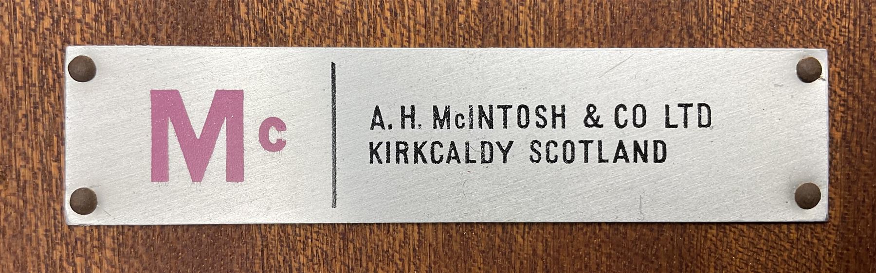 AH McIntosh & Co of Kirkaldy - mid-20th century teak extending dining table, circular top, concealed integrated double leaf, raised on tapered supports, label plaque to underside of leaf, together with a set of six chairs upholstered in black leatherette