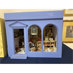 Three scratch-built wooden shop dioramas - single room Pet Shop with hinged front, fully furnished and well stocked with animals, birds and numerous accessories; and matching Garden Shop, fully furnished and well stocked with fruit, vegetables and garden accessories including lawn mower, wheelbarrows etc; each W34cm H27cm D26cm; and double fronted single room Butchers Shop with butcher at his block, partially stocked counter and two delivery cycles W57cm (3)
