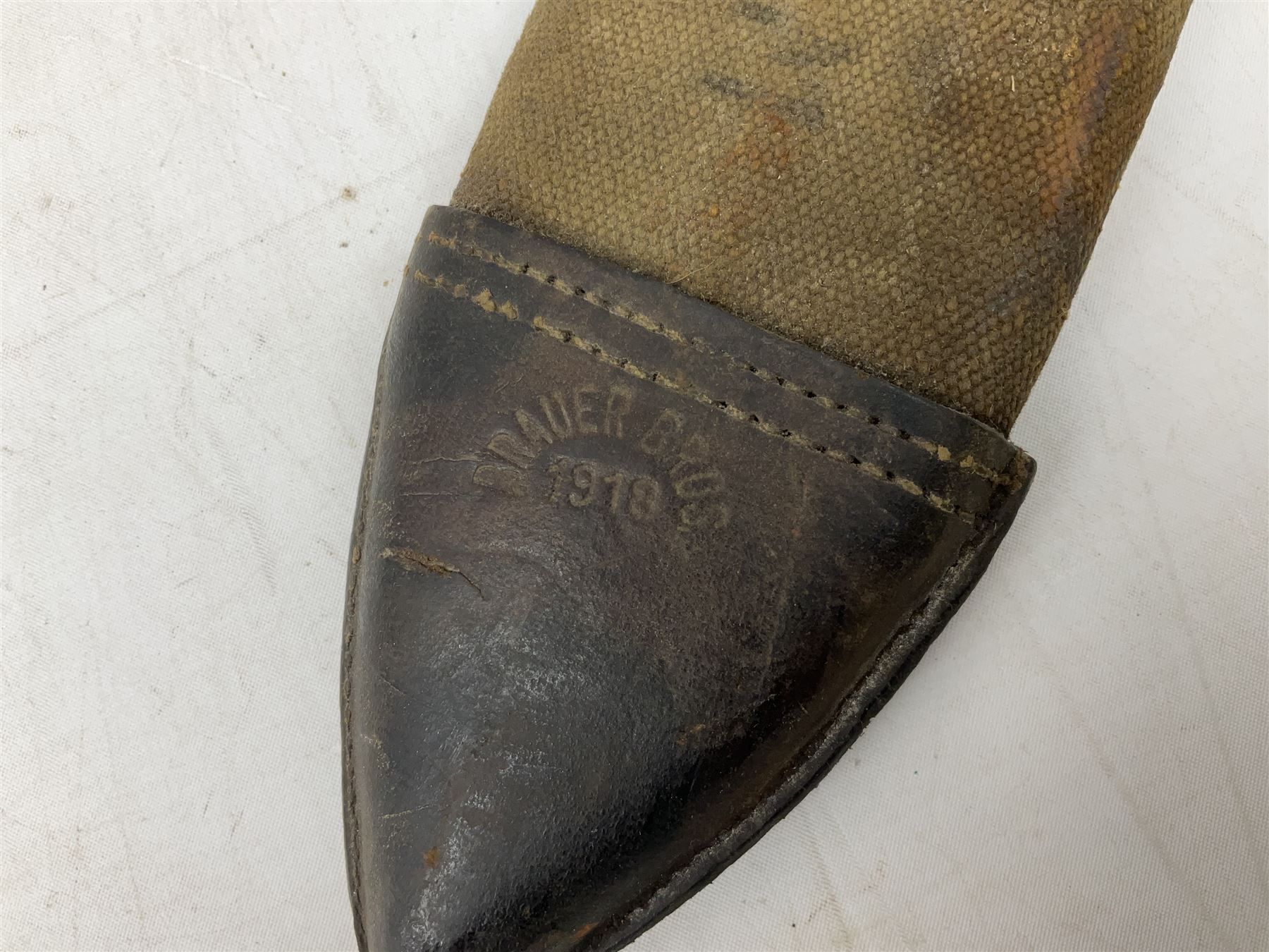 US Model 1910/17  Machine Gunners Bolo knife, the 26.5cm curving steel blade marked 'US MOD 1917 PLUME PHILA 1918'; in webbing covered steel scabbard with leather chape marked 'Brauer Bros 1918' L40.5cm overall (with photocopy of modern reference material)