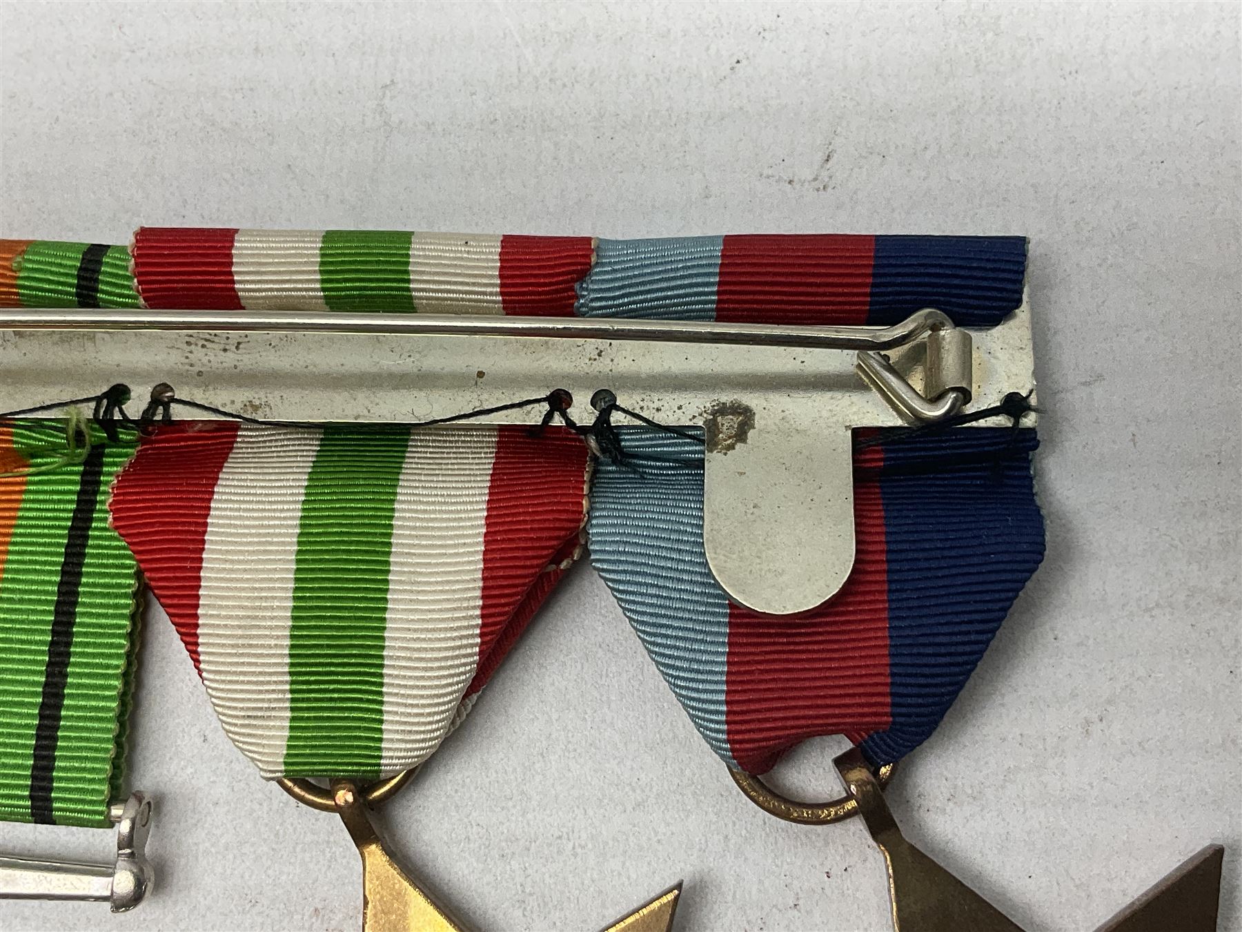 WW2 group of four medals comprising 1939-1945 War Medal, Defence Medal, Italy Star and 1939-1945 Star; with Royal Army Service Corps cap badge and RASC chrome and enamel sweetheart brooch