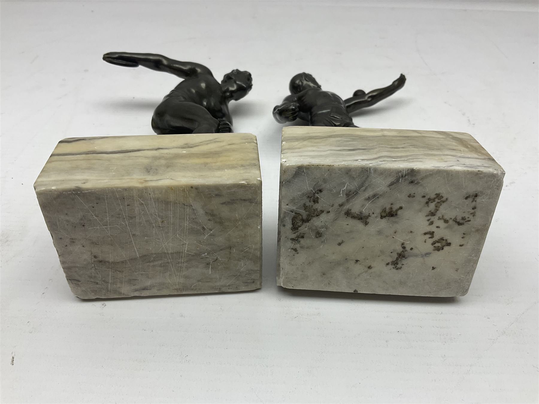 Bronzed model of the discus thrower and another of a episkyros player, both raised upon retangular plinths, H18cm