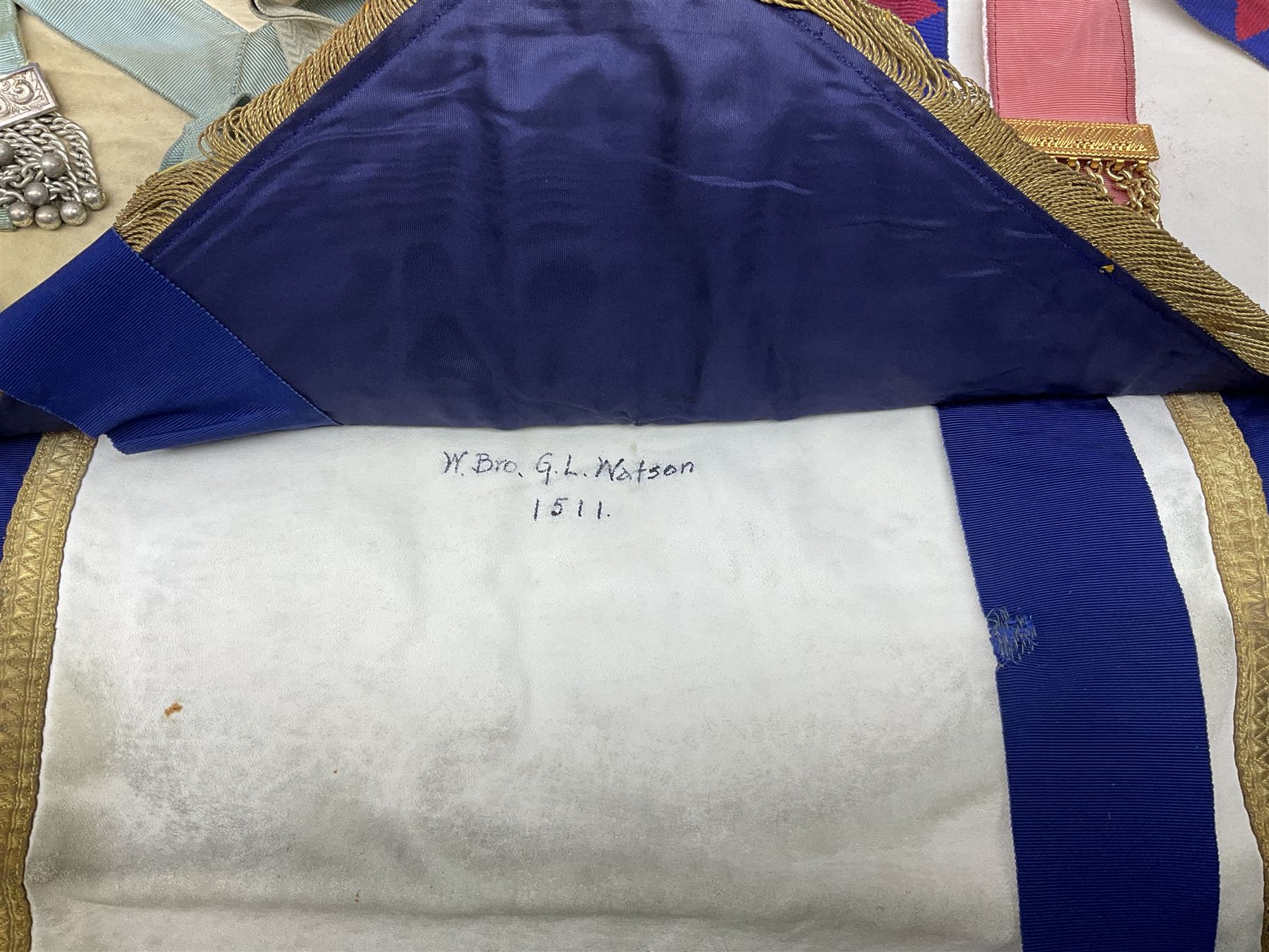 Two Masonic kid leather aprons, one with sash and cuffs, the other with sash, each marked 'Yorkshire North and East Ridings'; and three other unmarked Masonic aprons with sashes