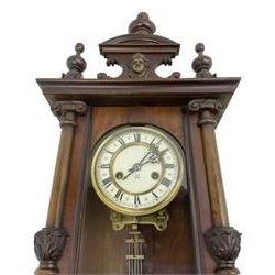 German - Hamburg American Clock Company Vienna style 8 day wall clock c 1900, mahogany case  with a carved pediment and finials, fully glazed case door with attached pilasters and carved ionic capitals, two part dial with Roman numerals and pierced steel hands, with a gridiron pendulum and twin train spring driven countwheel striking movement.
