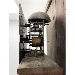 19th century carved oak longcase clock, projecting cornice over guilloche carved frieze, square brass dial with silvered Roman chapter ring and calendar aperture, decorated with ornate mask cast spandrels, the trunk door and base carved with potted plant, twin train driven eight day movement striking on bell