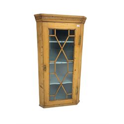 Early 19th century pine corner cabinet, projecting dentil cornice over astragal glazed door