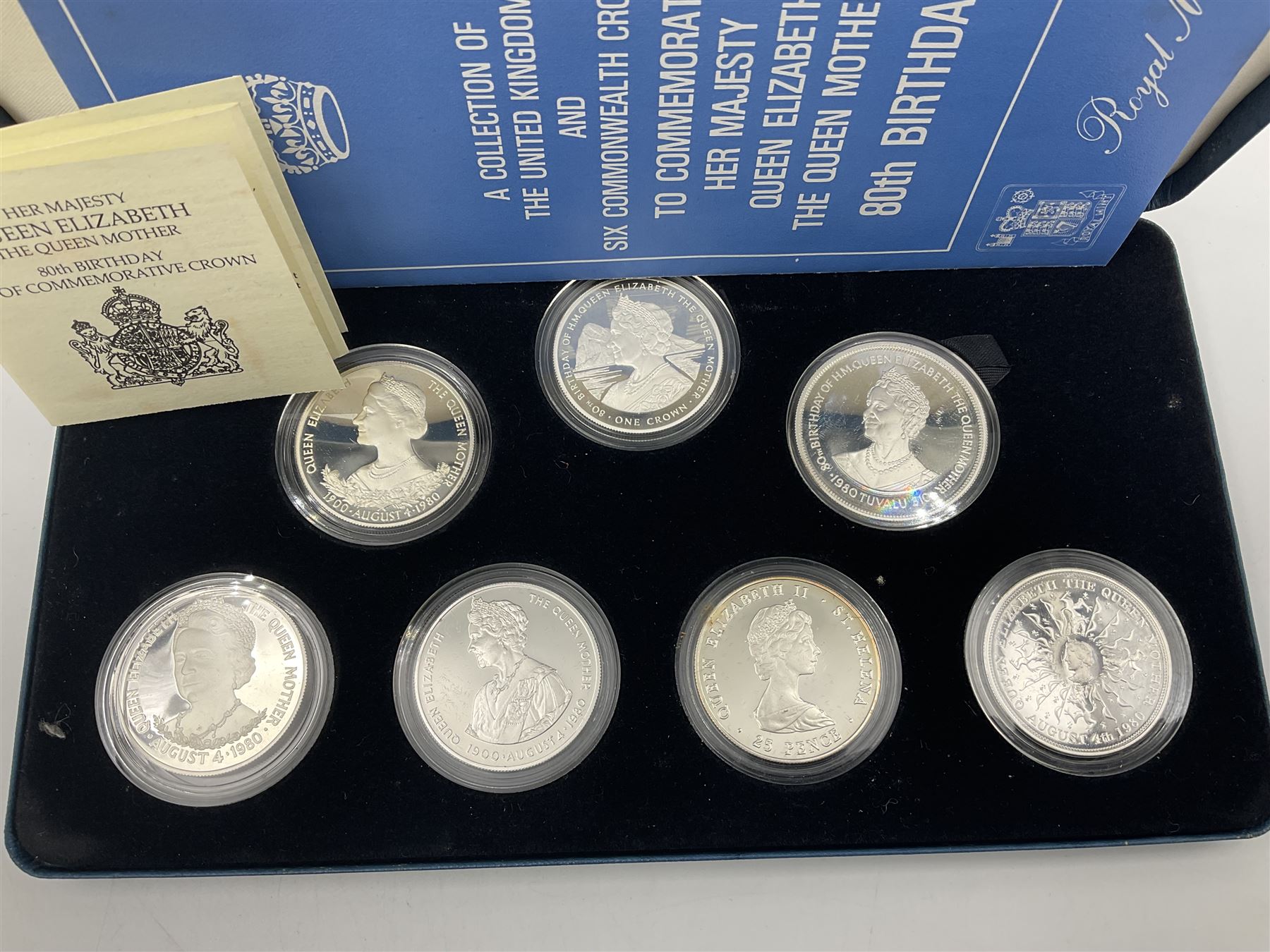 The Royal Mint silver proof seven coin set, comprising United Kingdom and six Commonwealth crowns, commemorating 'Her Majesty Queen Elizabeth The Queen Mother's 80th Birthday', cased with certificate