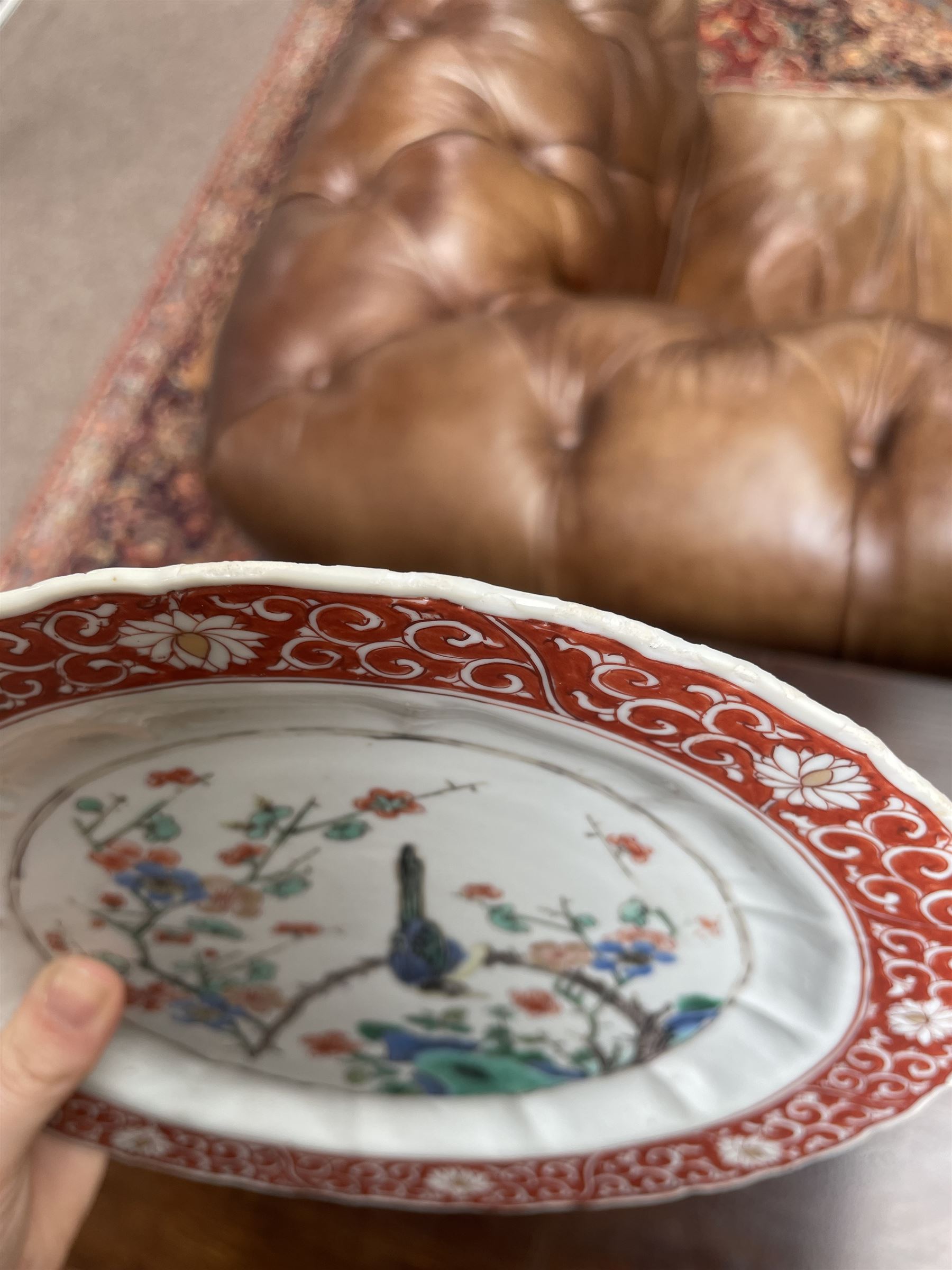 Chinese Kangxi famille verte plate, decorated with a bird perched upon a blossoming branch, within an iron red foliate border, D22cm