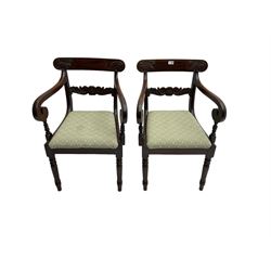 Pair of mahogany regency carver elbow chairs, the cresting and centre rail carved with scroll and foliate decoration, over scrolled arms and drop in seat pad upholstered in laurel green fabric, raised on turned supports