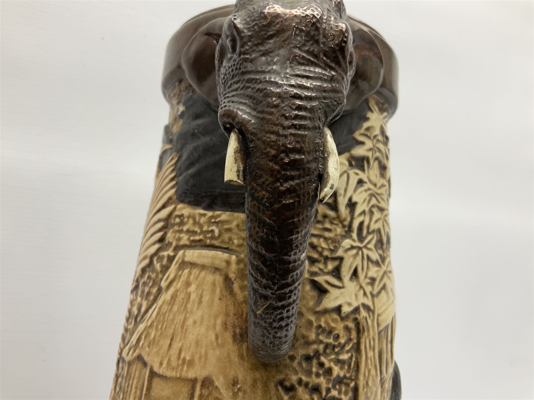 Pair of Bretby vases of tapering cylindrical form decorated with elephants, cranes and fishermen, the bodies with twin elephant mask handles, with coppered borders, raised upon three bun feet, stamped Bretby 2246 marks beneath, H32cm