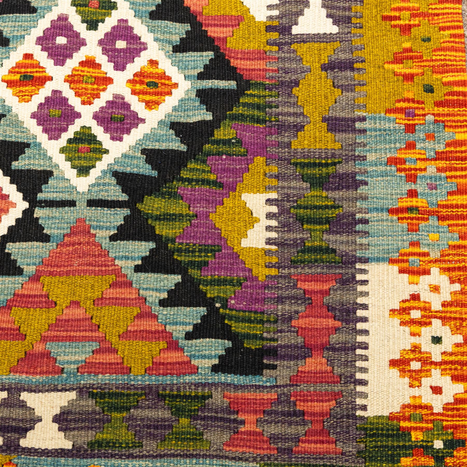 Afghan Maimana flatweave kilim runner, central field features large bold nested diamond motifs and stylized geometric lozenge patterns on olive purple, ochre, blue, and green tone ground, border stripe in orange tones with fringe
