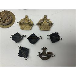 Over thirty British and Continental military metal badges; together with quantity of shoulder titles, collar dogs, rank pips, uniform buttons etc