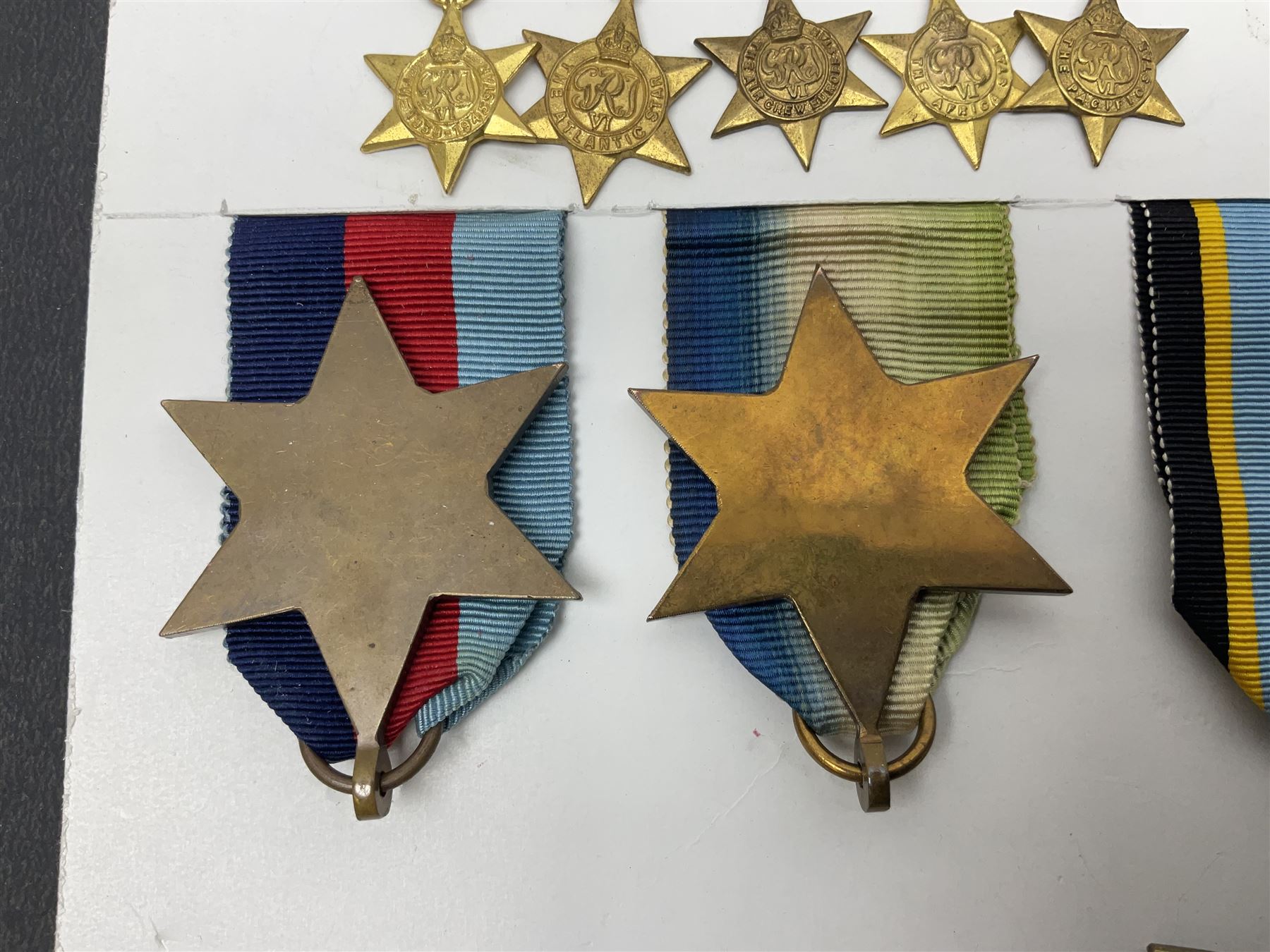 Representative display of WWII Campaign stars comprising 1939-1945 Star, Atlantic Star, Air-Crew Europe Star, Africa Star and Pacific Star; together with the corresponding group of miniatures; all with ribbons