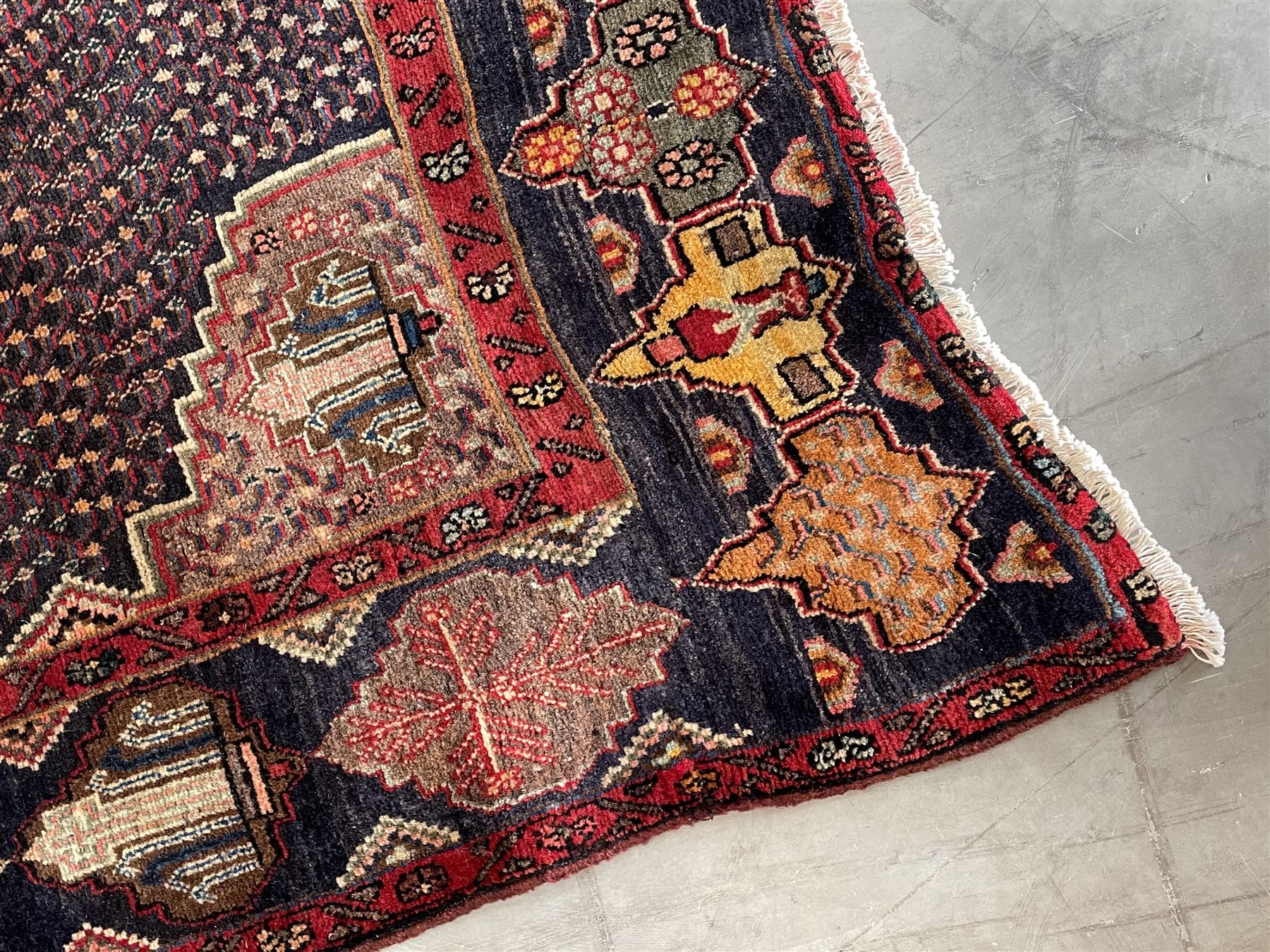 Persian Hamadan blue ground rug, medallion on field decorated with repeating motifs, the guarded border with multiple medallions decorated with flower heads and stylised motifs