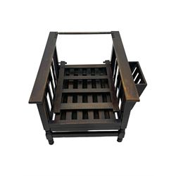 Late Victorian oak steamer chair, adjustable slatted backrest with grooved crest rail, wide armrests extending to a sliding adjustable footrest, open frame sides with vertical slats, side magazine rack and collapsible table, raised on turned front supports