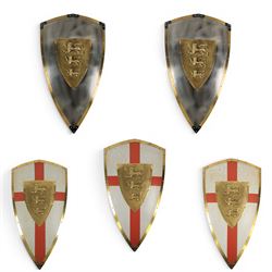 Five wall hangings, modelled as shields, decorated to the centre in relief with three lions 