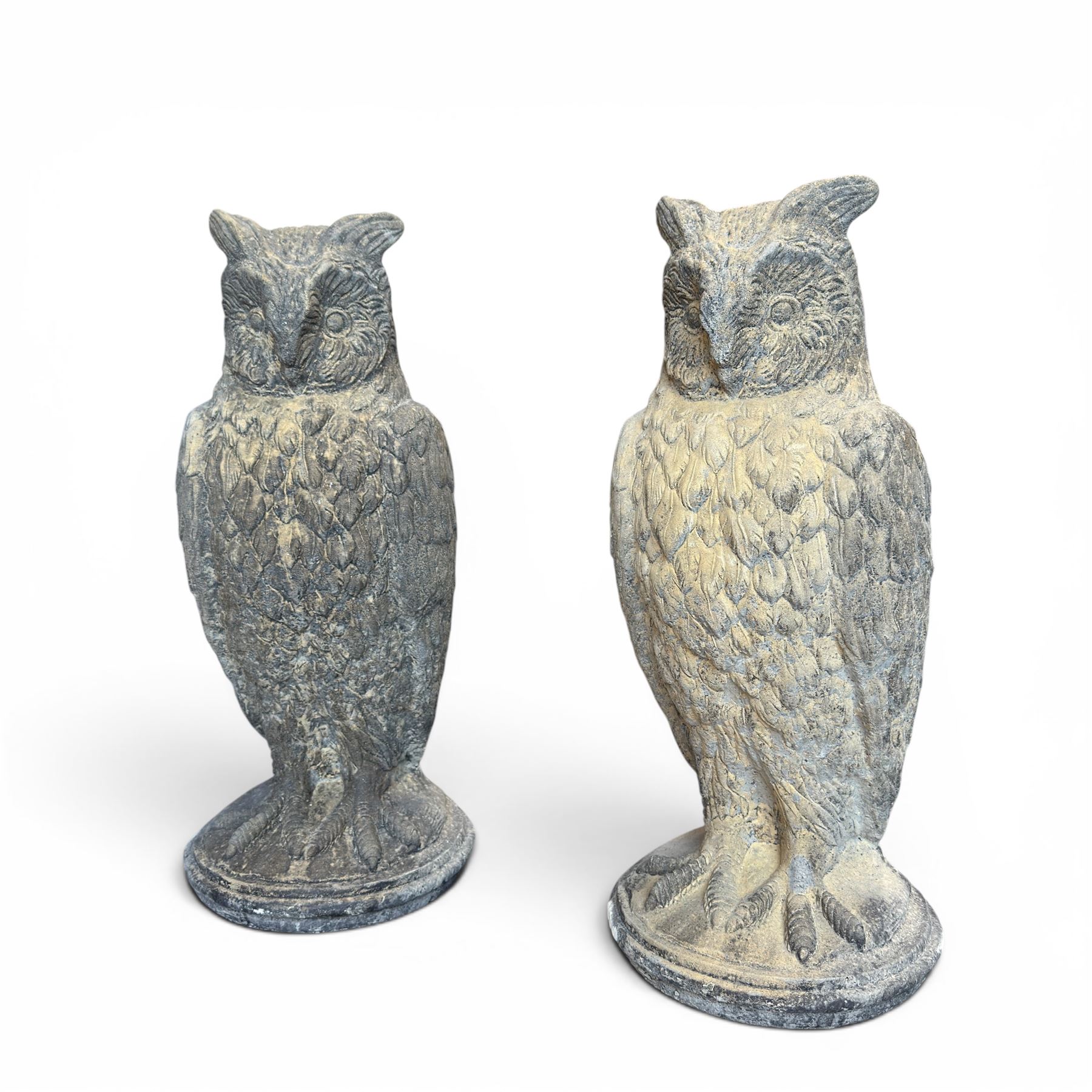 Pair of large composite stone garden statues modelled as standing horned owls, raised on circular bases
