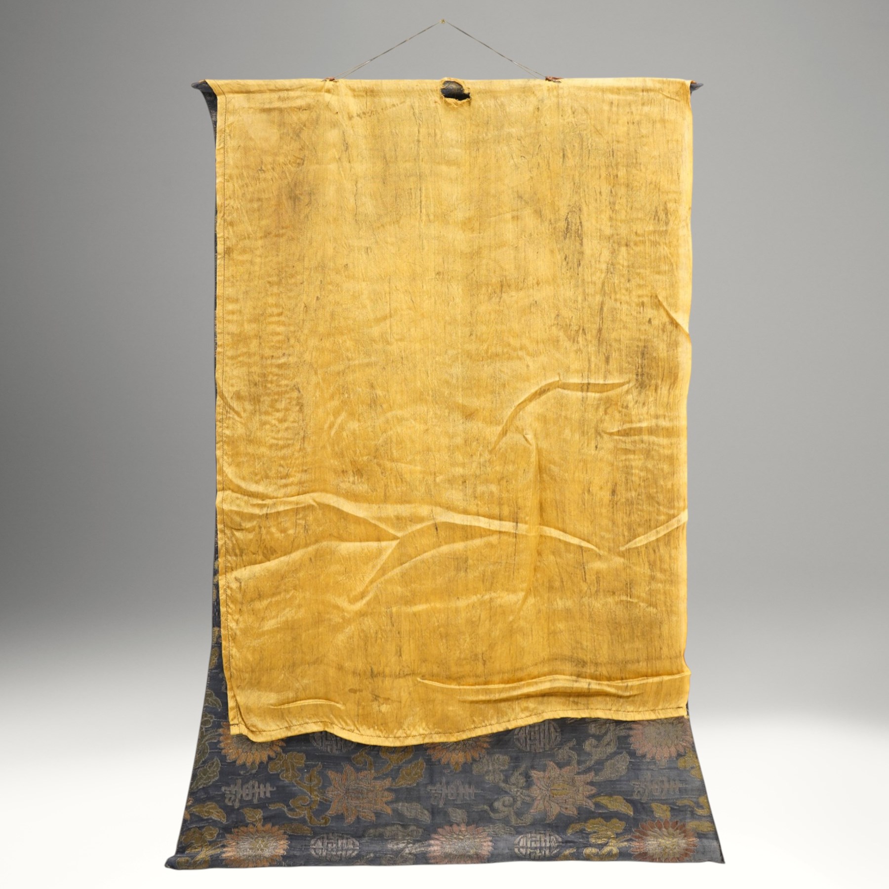 Two 19th century Tibetan Thangkas, depicting Bhavachakra or the Wheel of Life, and the other depicting a Buddhist mandala, each mounted on brocaded fabric, image sizes 64cm x 46cm and 62cm x 47cm (2)