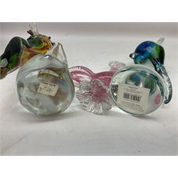 Three Murano style glass cockatoo parrots, the first with mottled yellow, red and orange body, clear outstretched wings, dark blue beak and red crest, raised upon clear stylised base, the second smaller parrot with merging blue and green body, and further with pink striped body, tallest H40cm