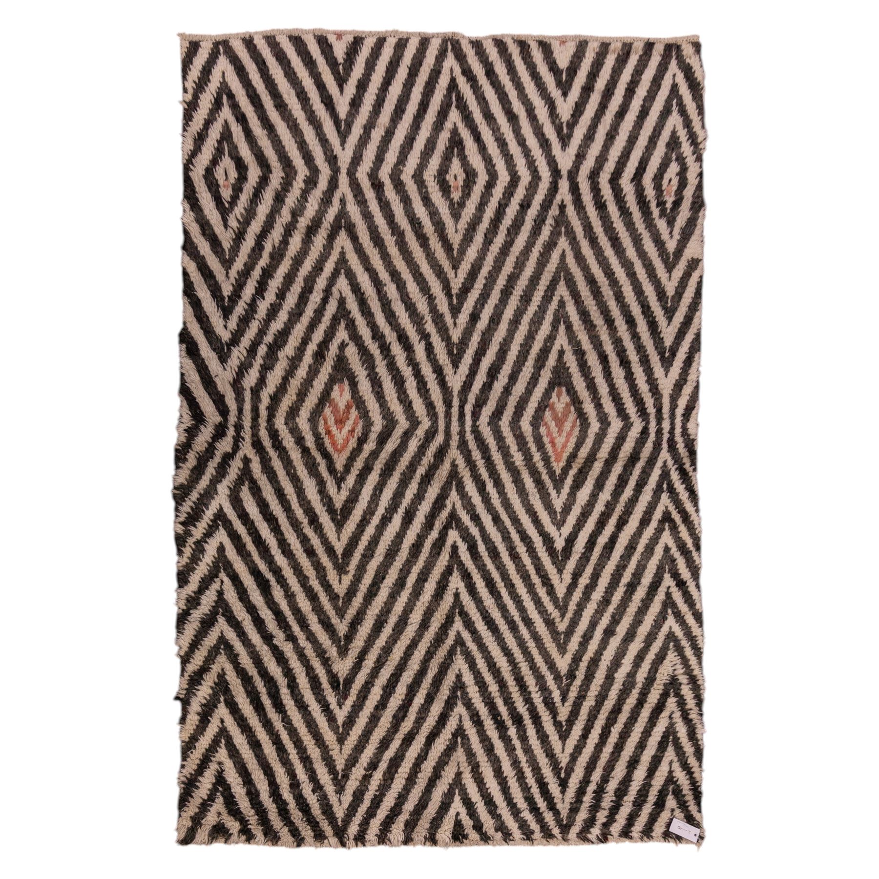 Moroccan Berber hand-knotted rug, of rectangular form, ivory ground decorated with bold, repeating lozenge motifs defined by alternating charcoal grey linear bands, with a striking geometric lattice and chevron with diamond designs, enclosing smaller stylized devices in soft blush tones, with fringe ends