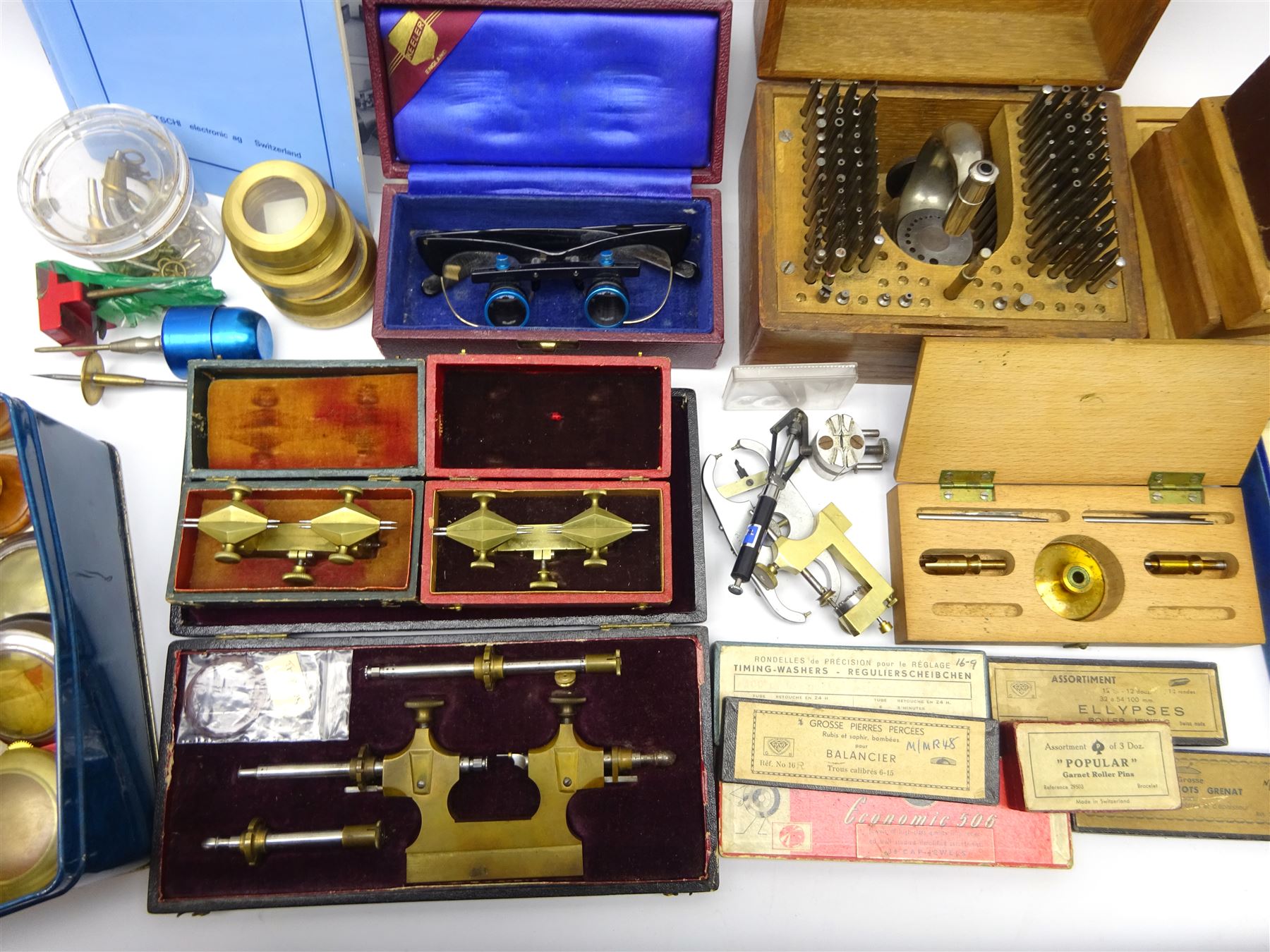 Collection of horologists/watch maker's tools and equipment including Tour a Pivoter, Staking tool by Kendrick & Davis patented Aug 26 1902, mainspring winders, two depthing tools, Poising tool, Witschi timegrapher (no power lead), Keeler optician glasses and collection of watch parts including cock balancers, hands, roller jewels etc