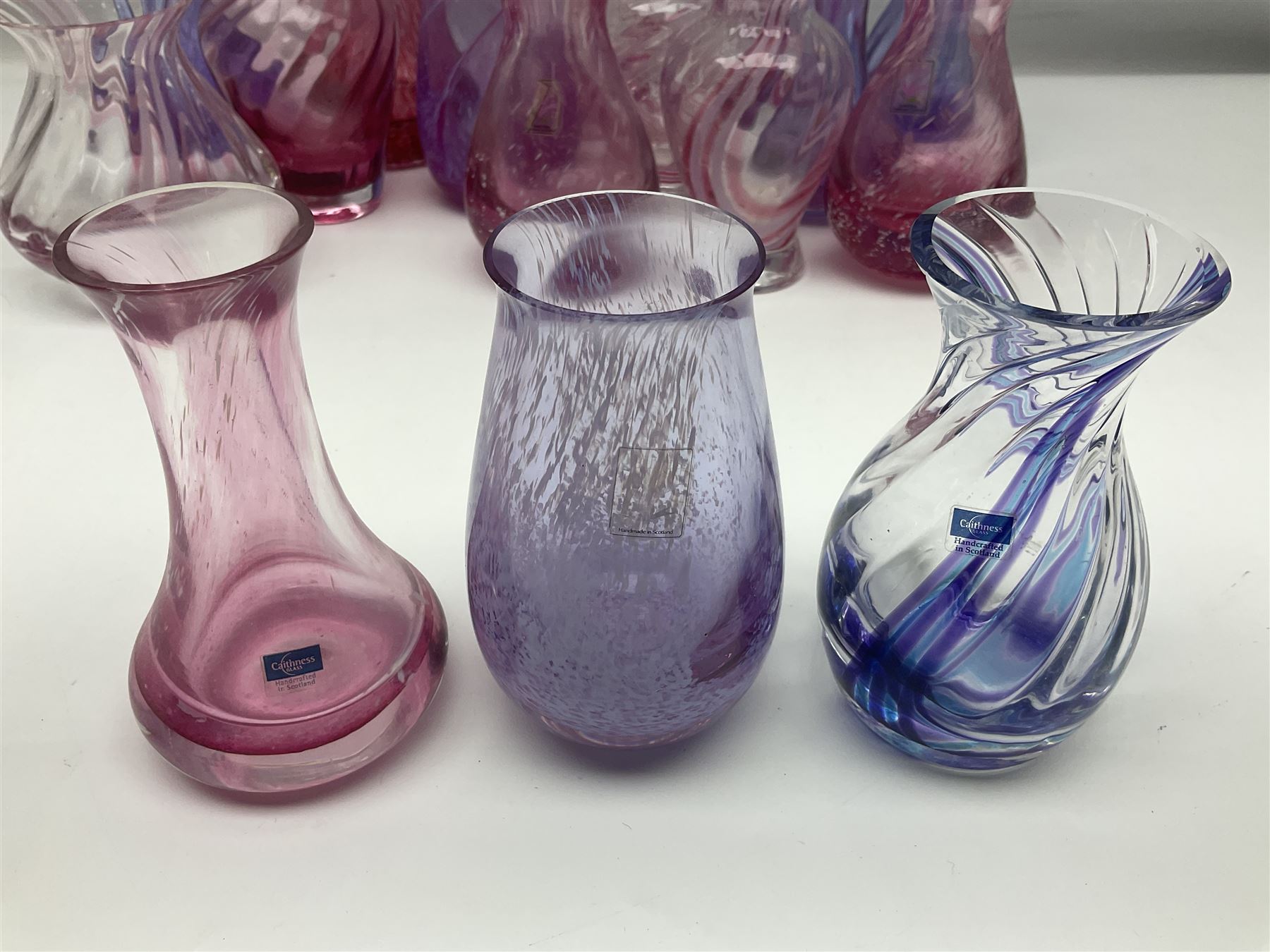 Collection of pink/purple Caithness glass vases, to include mottled and swirl designs, largest 20cm (19)