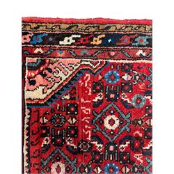 Persian crimson ground runner, the field decorated with Herati motifs,  three-band border, the main band decorated with repeating flowerheads 